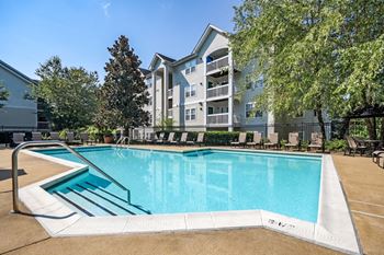 Our apartments offer a swimming pool with a patio and trees